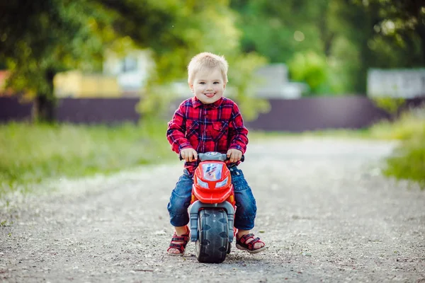 Kleine jongen op een fiets van de kinderen in het park — Stockfoto