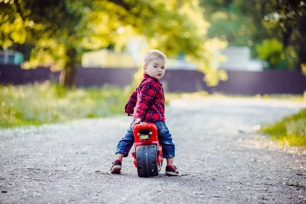 Kleine jongen op een fiets van de kinderen in het park — Stockfoto