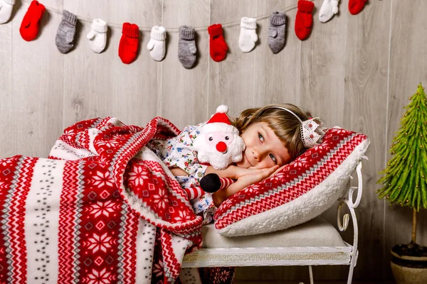 Petite fille couchée au lit attendant Noël — Photo