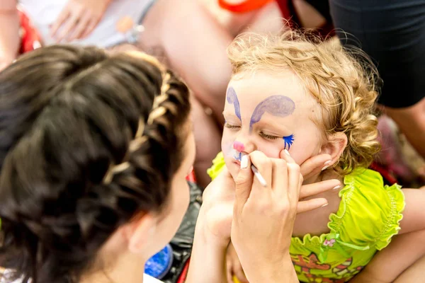 Donna pittura faccia di bambino all'aperto — Foto Stock