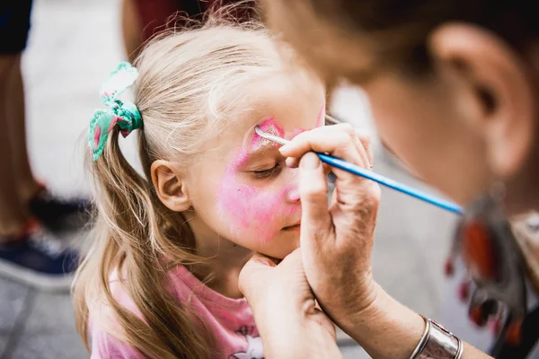 Frau bemalt Kindergesicht im Freien — Stockfoto