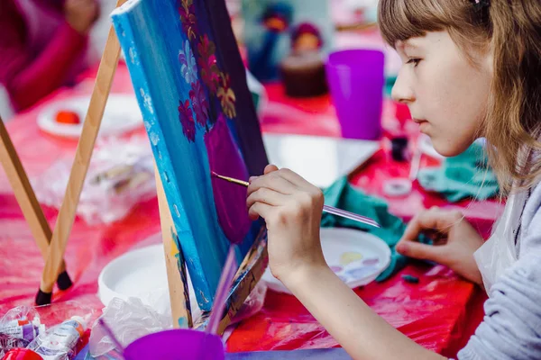 Mädchen malt auf Staffelei Blumen — Stockfoto