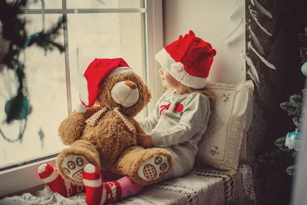 Bambina felice seduta nella finestra invernale Natale — Foto Stock