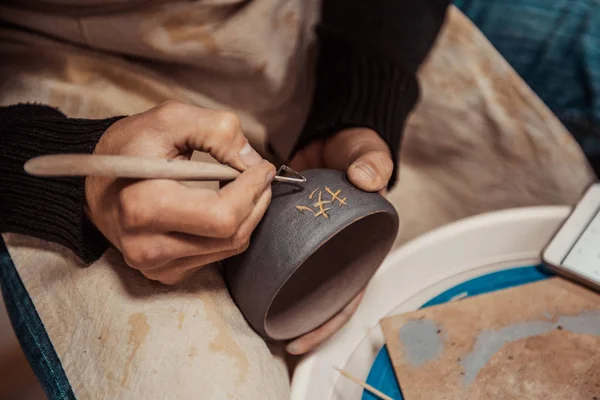 Close-up em mãos de artista personalizando um copo de barro, escrevendo o caráter chinês — Fotografia de Stock