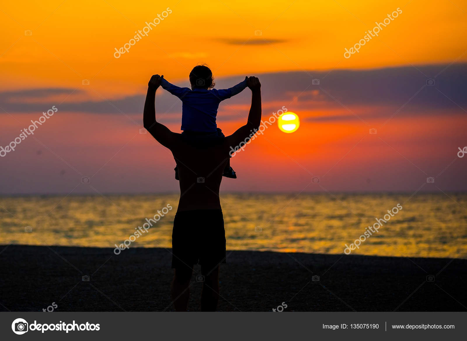 Father throwing his kid up in the air on the beach, silhouette shot
