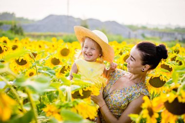 Anne ve kızı ayçiçeği tarlasında