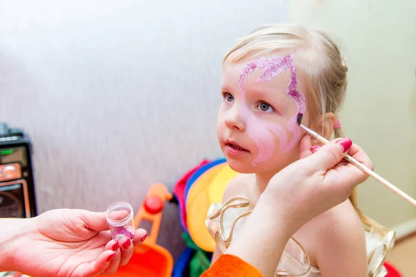 Kvinna målning ansikte av kid utomhus — Stockfoto