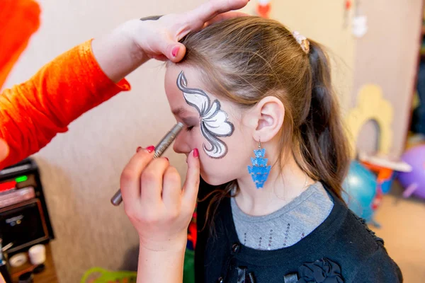 Woman painting face of kid outdoors — Stock Photo, Image