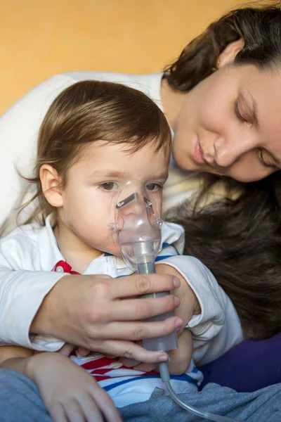 Młoda kobieta z synem robi inhalacji z nebulizatora w domu — Zdjęcie stockowe