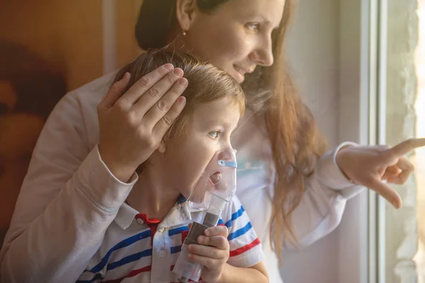 家でネブライザー吸入をやって息子を持つ若い女性 — ストック写真