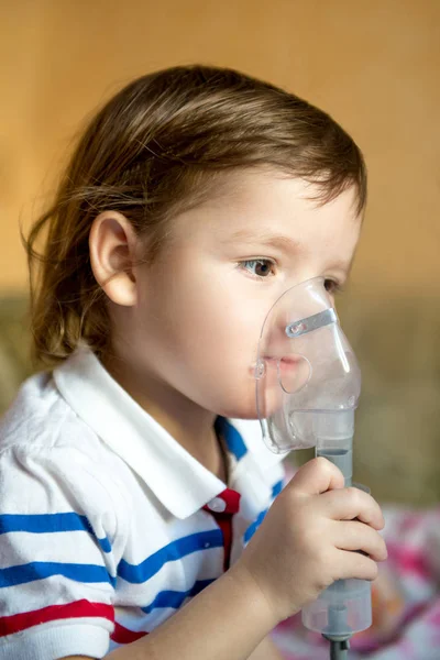 Petit garçon mignon avec des problèmes d'asthme ou d'allergie, rhume, en utilisant un inhalateur à la maison . — Photo