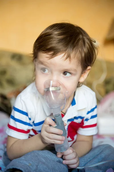 Niño lindo con problemas de asma o alergia, resfriados, uso de inhalador en casa . — Foto de Stock