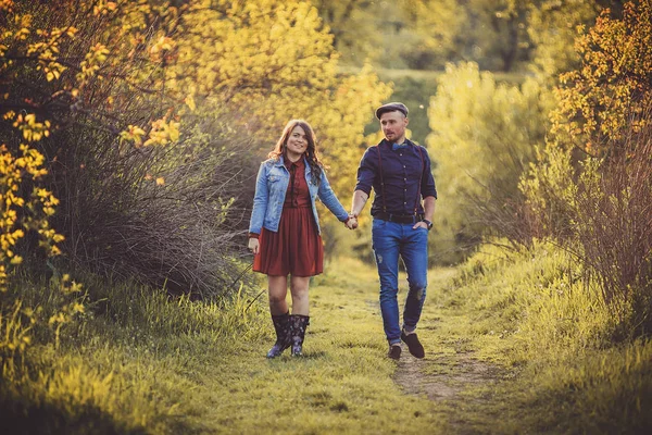 Älska ungt par promenader i parken höll händer — Stockfoto