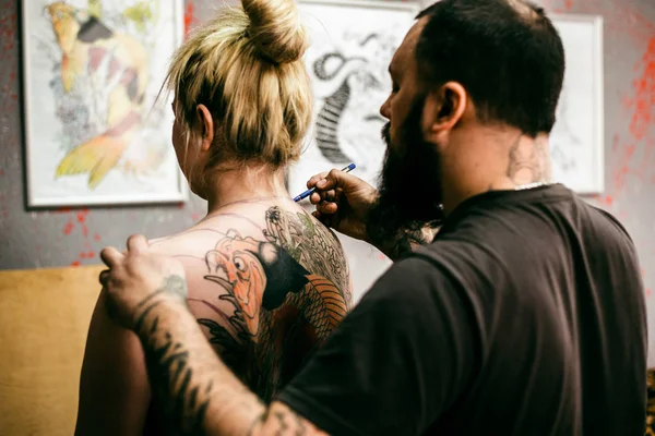 El proceso de crear un tatuaje en la espalda de una chica —  Fotos de Stock