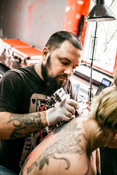 bir kızın arkasına bir dövme oluşturma işlemi