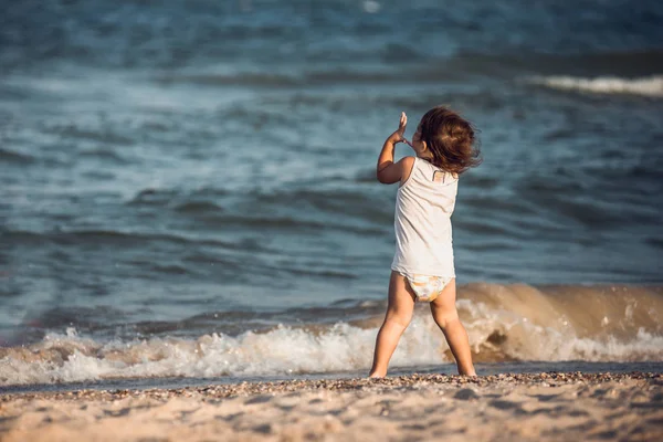 Silueta de niño en la playa, levantando las manos — Foto de Stock