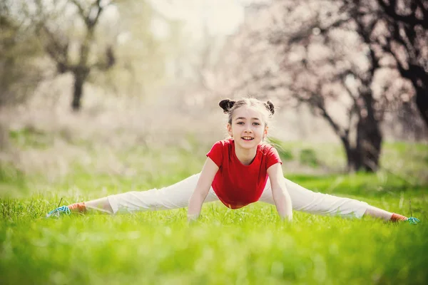 Glad flicka gör splittringen på gräset — Stockfoto