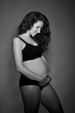bir güzel genç hamile kadın, stüdyo arka plan üzerinde siyah beyaz portre