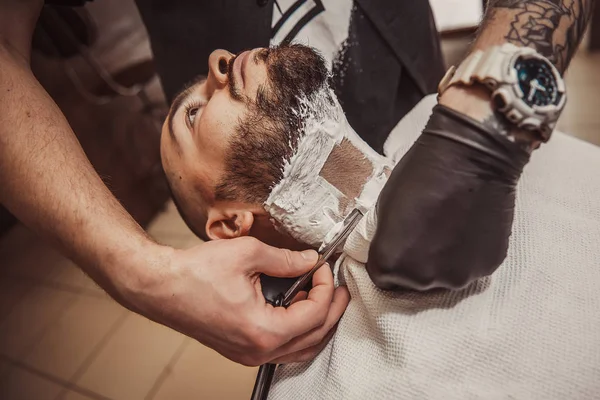 Hombre afeitándose la barba en el peluquero profesional —  Fotos de Stock