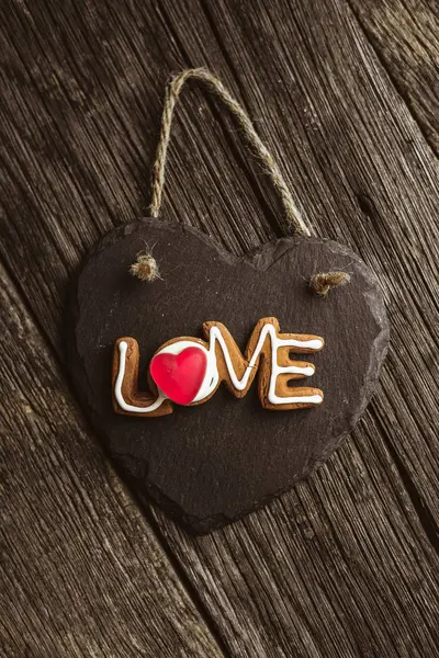 Λέξη αγάπη γράφεται με σπιτικά cookies σε ένα ξύλινο τραπέζι. Ημέρα του Αγίου Βαλεντίνου — Φωτογραφία Αρχείου