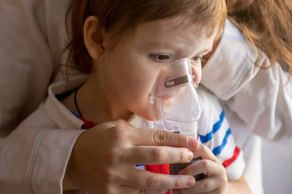 Jovem mulher com filho fazendo inalação um nebulizador em casa — Fotografia de Stock