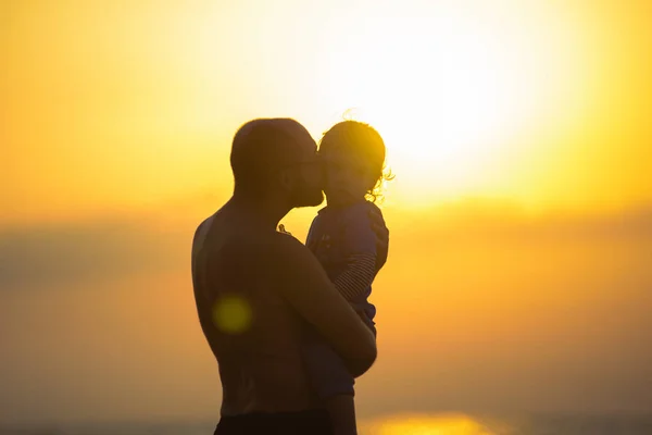 Gün batımı sırasında babası ile küçük bebek silüeti. — Stok fotoğraf