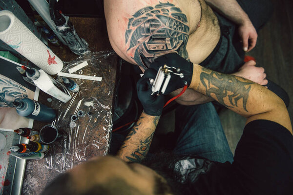 the process of creating a tattoo on the back of a man