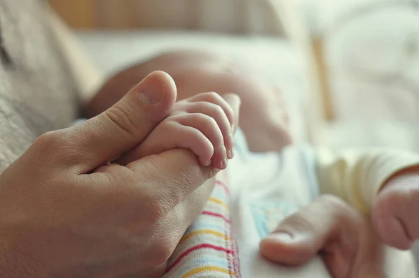 Un padre sostiene la mano de su bebé —  Fotos de Stock