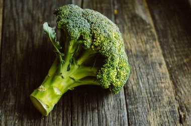 Eski ahşap masa üzerinde ham taze brokoli.