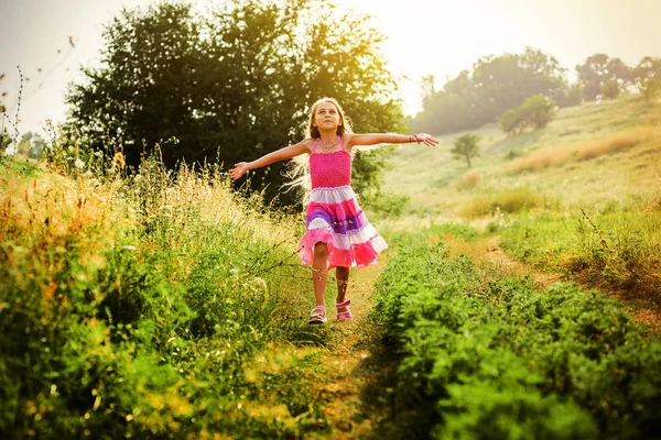Running open armen weinig gelukkige meisje groene weide veld bijhouden — Stockfoto