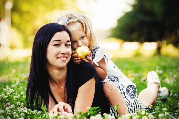 Mãe e seu filho desfrutar do início da primavera, comendo maçã, feliz . — Fotografia de Stock