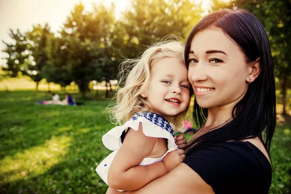 Madre sosteniendo hija al aire libre sonriendo —  Fotos de Stock