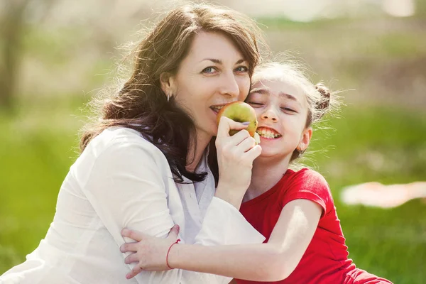 Матері і дитини насолоджуватися на початку весни, харчової apple, щасливі. — стокове фото