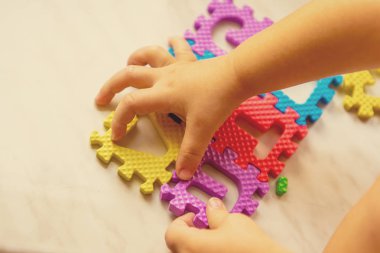 Renkli köpük bulmaca harf ve rakam masa lambası üzerinde çocuğun elinde