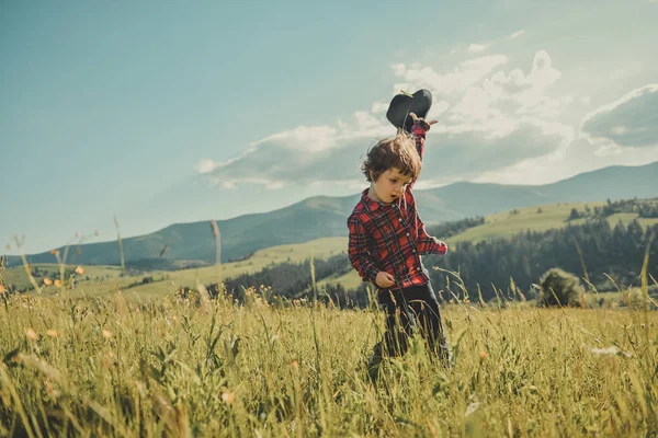 幸せな少年が山の上に実行しています。山の丘の上に彼の手で帽子の子。カルパティア山脈 — ストック写真