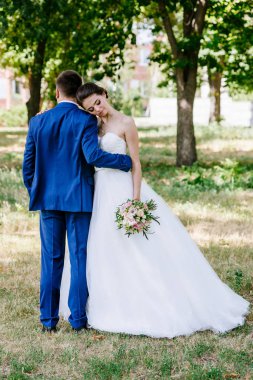 Gelin ve damat gün açık havada yürüyüş düğününde Doğa bahar. Gelin Damat parkta sarılma