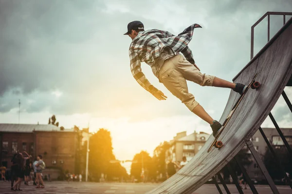 Skateboarder pada menggiling dengan latar belakang awan gelap di taman skate lokal . — Stok Foto