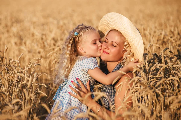 Bela jovem mãe e sua filha se divertindo no campo de trigo — Fotografia de Stock