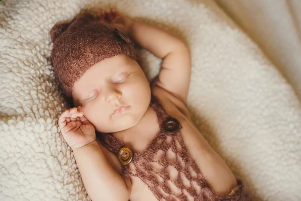 Niño recién nacido durmiendo en una manta esponjosa. El bebé en un sombrero de punto está durmiendo dulcemente. — Foto de Stock