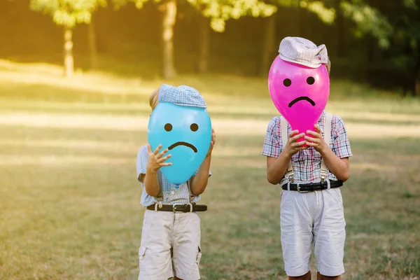 Два хлопчики ховаються за червоними і синіми кульками — стокове фото