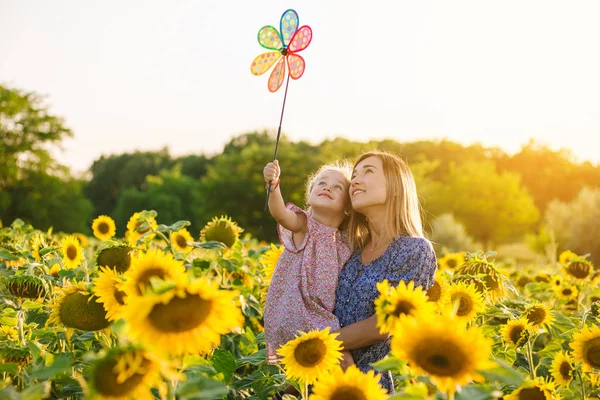 Мама и дочь в поле подсолнухов — стоковое фото