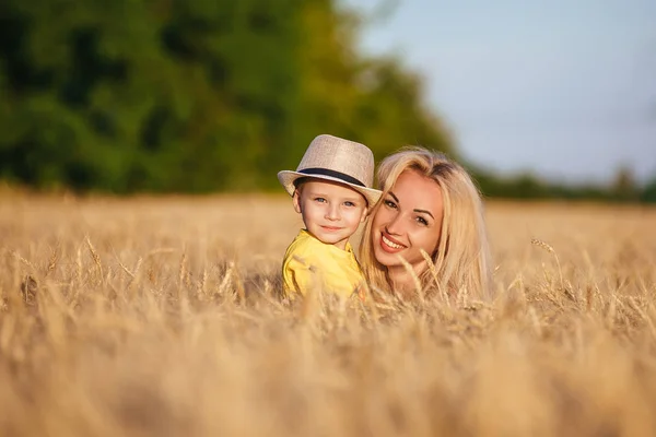 Красивая молодая мать гуляет со своим маленьким сыном по пшеничному полю . — стоковое фото