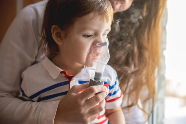 Młoda kobieta z synem robi inhalacji z nebulizatora w domu — Zdjęcie stockowe