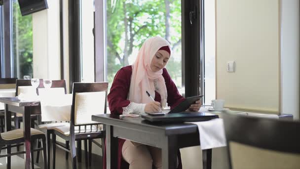 Hermosa mujer musulmana en el café con la tableta — Vídeos de Stock