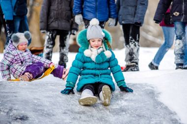 Mutlu çocuk küçük bir karlı tepeden kayar. Etkin kış açık havada eğlence