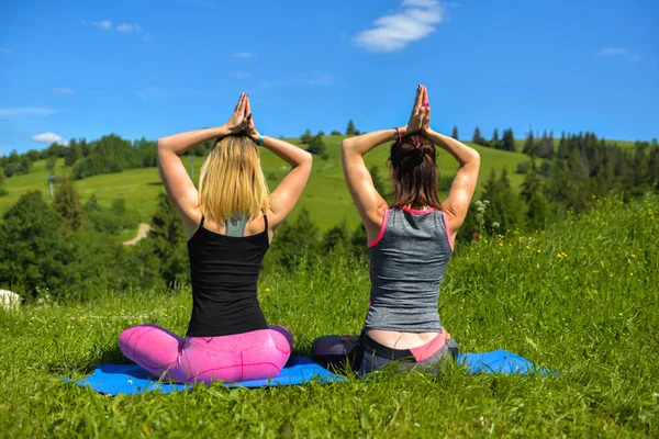 Zwei Sportmädchen sitzen und tun Pose Yoga — Stockfoto