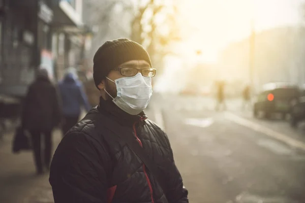 Un hombre con una máscara en la calle. Protección contra virus y agarre — Foto de Stock