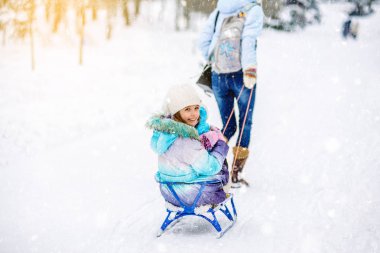 Anne küçük kızı kızağa kışın rulo