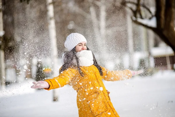 Young woman throwing snow