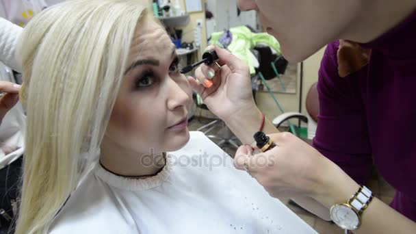 Make-up artist sprawia, że makijaż rzęs w młodą kobietę. Makijaż. Kosmetyk. Baza do makijażu Perfect Make-up.Applying. — Wideo stockowe